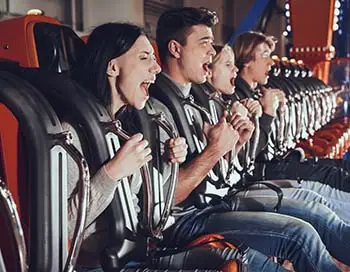 A group of thrill-seekers strapped into an amusement park ride, screaming as it sets off