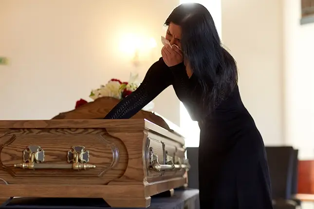 Woman mourning a death at a casket.